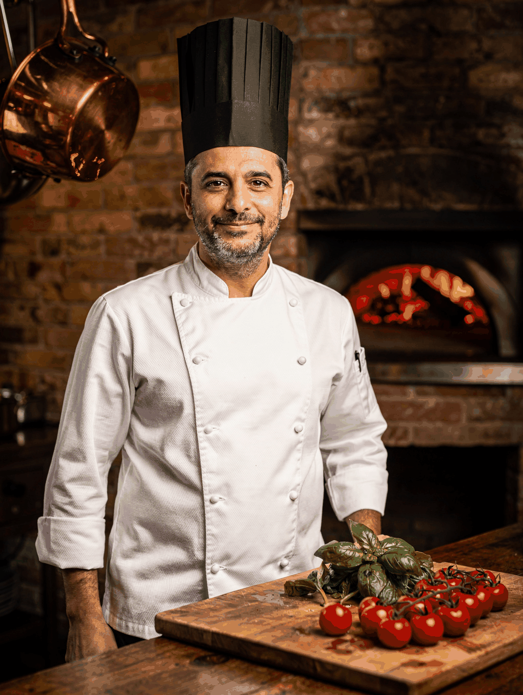 Chef Alessandro Conti tending to the wood-fired hearth