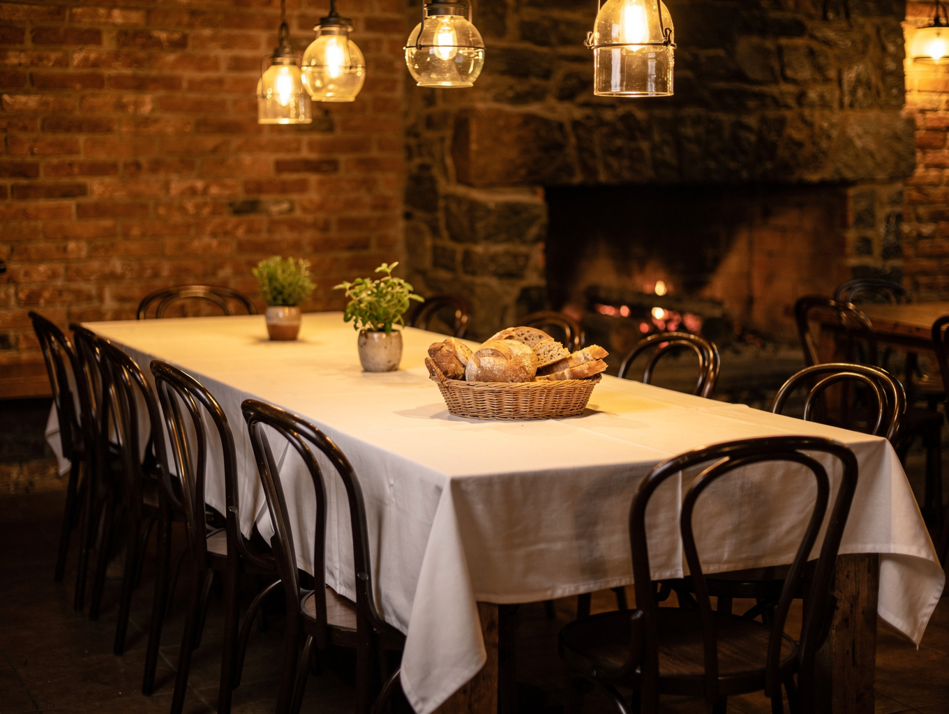 Warm candlelit main dining room with textured linen tables and intimate seating